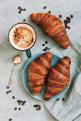 French croissant roll with coffee. Appetizing breakfast with pastries. View from above.