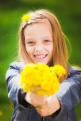 portrait of smiling young girl holding bouquet of flowers in hands