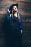Cowgirl jeans fashion woman with long blonde hair. Standing against wooden wall.