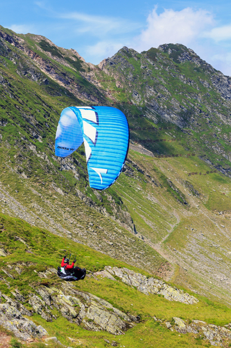 Balea Lake, Romania - JULY 21, 2014: Unidentified paraglider in Balea Lake, Fagaras Mountain, Romania. Paragliding is one of the most popular adventure sports in the world