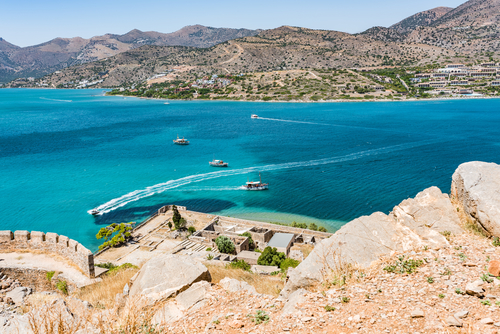 Top of Spinalonga fortress. View to blue aegian sea with boats, and Mirabello coast.